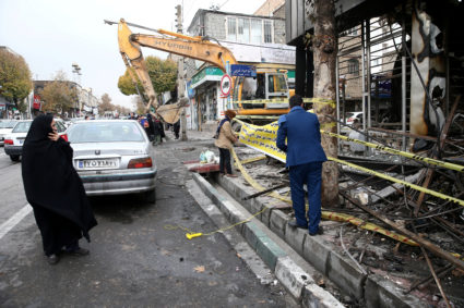 FILE PHOTO: A woman looks on as people hang a banner outside a burnt bank, after protests against increased fuel prices, in Tehran, Iran November 20, 2019. Photo by Nazanin Tabatabaee/WANA (West Asia News Agency) via REUTERS ATTENTION EDITORS - THIS IMAGE HAS BEEN SUPPLIED BY A THIRD PARTY/File Photo