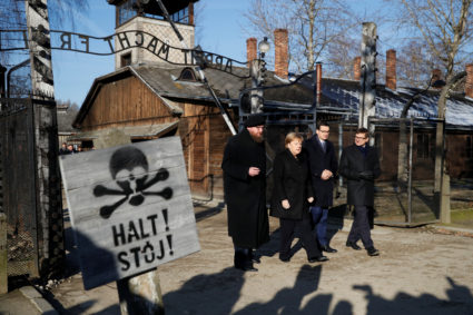 German Chancellor Angela Merkel, Poland's Prime Minister Mateusz Morawiecki and museum director Piotr Cywinski walk past the "Arbeit Macht Frei" gate at the former Nazi German concentration and extermination camp Auschwitz in Oswiecim, Poland, December 6, 2019. Photo by Kacper Pempel/Reuters