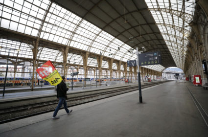 A French SNCF railway worker on strike holds a CGT labour union flag as he walks on a platform at Nice railway station as the nationwide strike continues against French government's pensions reform plans, France, December 6, 2019. Photo by Eric Gaillard/Reuters