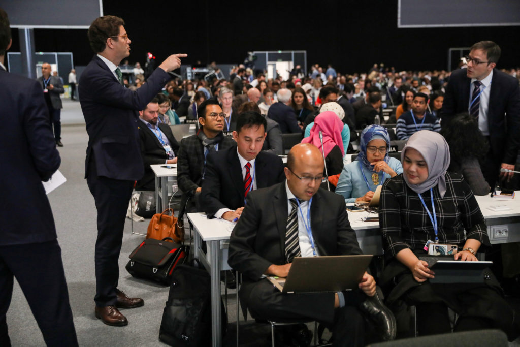 Brazil's Environment Minister Ricardo Salles talks with other delegation members, ahead of a plenary session during the U....