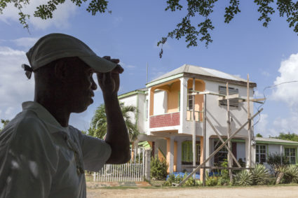 On 7 November 2019, on the island of Barbuda, James Gerald stands in front of his family’s home, which was damaged by Hurricane Irma in September 2017. James and his family — mother Corine, son James Jr., 13, and daughter Jerrene, 11 — were evacuated to Antigua from Barbuda following Hurricane Irma. Photo courtesy: UNICEF