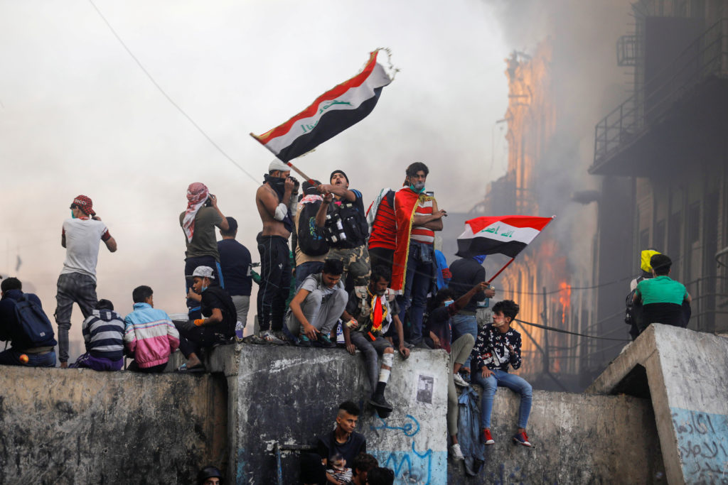 A demonstrator carries the Iraqi flag during ongoing anti-government protests, in Baghdad on November 30. Photo by Khalid ...