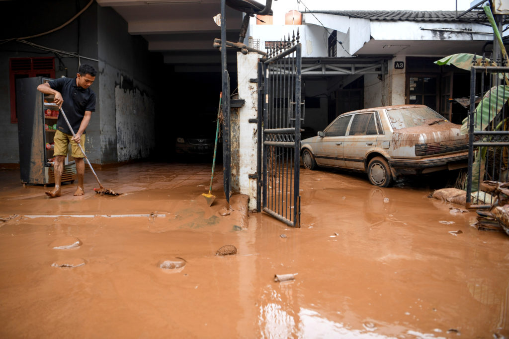 A man cleans up the clay after floods hit a residential area in Bintaro, Jakarta, Indonesia, January 3 2020 in this photo ...