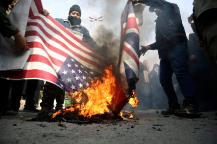 Demonstrators burn the U.S. and British flags during a protest against the assassination of the Iranian Major-General Qassem Soleimani, head of the elite Quds Force, and Iraqi militia commander Abu Mahdi al-Muhandis who were killed in an air strike in Baghdad airport, in Tehran, Iran January 3, 2020. Photo provided by WANA (West Asia News Agency)/Nazanin Tabatabaee via REUTERS