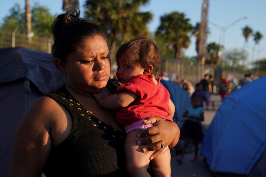 Honduran asylum seeker Daisy V. Villalobos, 32, carries her five-month-old daughter Jimena L. Montoya in an encampment nea...