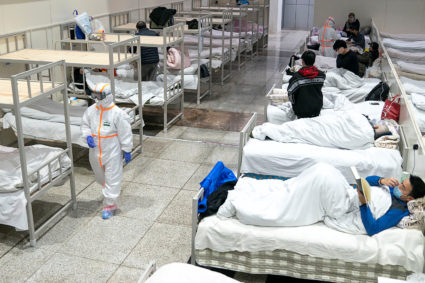 Medical workers in protective suits attend to patients at the Wuhan International Conference and Exhibition Center, which has been converted into a makeshift hospital to receive patients with mild symptoms caused by the novel coronavirus, in Wuhan, Hubei province, China February 5, 2020. Picture taken February 5, 2020. China Daily via Reuters