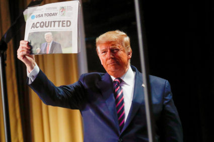 U.S. President Donald Trump holds up a copy of USA Today's front page showing news of his acquitttal in his Senate impeachment trial, as he arrives to address the National Prayer Breakfast in Washington, U.S., February 6, 2020. Photo by Leah Millis/Reuters