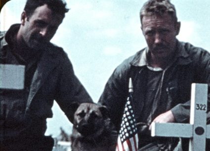 A 16mm film frame of two Marines in the Marine Corps’ 5th Division cemetery on Iwo Jima, who pay their respects to a fallen comrade. Image courtesy of United States Marine Corps Film Repository, USMC 101863