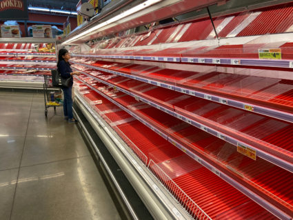 A shopper picks over the few items remaining in the meat section, as people stock up on supplies amid coronavirus fears, at an Austin, Texas, grocery store on March 13, 2020. REUTERS/Brad Brooks