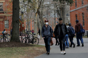 A student wearing a mask, because his cancer treatment has left him immunosuppressed and vulnerable to diseases such as the coronavirus, walks through the Yard at Harvard University, after the school asked its students not to return to campus after Spring Break and said it would move to virtual instruction for graduate and undergraduate classes, in Cambridge, Massachusetts, U.S., March 10, 2020. REUTERS/Brian Snyder