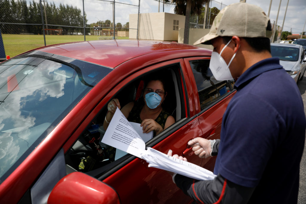 A man speaks with a library worker after receiving an unemployment form, as the outbreak of coronavirus disease (COVID-19)...