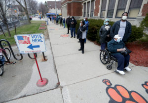 Rosie Redmon, 79, waits with her son, Deshawn Hudson, to vote in the presidential primary election while wearing masks and practicing social distancing to help slow the spread of coronavirus disease (COVID-19) at Riverside High School in Milwaukee, Wisconsin, U.S. April 7, 2020. Mike De Sisti/Milwaukee Journal Sentinel/USA TODAY NETWORK via REUTERS