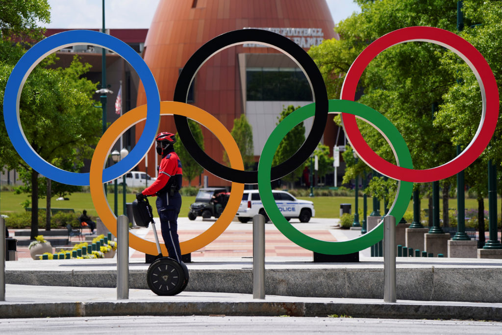 A security patrol on a Segway passes in front of the Olympic rings at Centennial Olympic Park days before the phased reope...