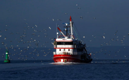 Seagulls fly over a fishing boat on the waters of the North Aegean Sea off the shores of Balikesir, Turkey, March 6, 2020. Photo by Umit Bektas/REUTERS