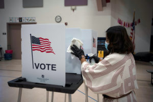 Election worker Gisela Alberg cleans a voting booth at Sonoma Elementary School during the primary election in Las Cruces, New Mexico, U.S., June 2, 2020. Photo by Paul Ratje/Reuters