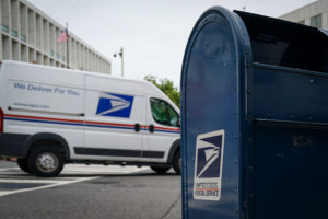 A U.S. Postal Service truck is seen driving past a a blue mail collection box on Capitol Hill in Washington, U.S., August 13, 2020. The U.S. Postal Service is a sticking point on the stalled congressional talks with the Trump administration on the latest coronavirus relief. REUTERS/Sarah Silbiger