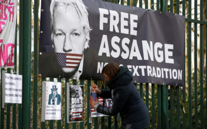 A supporter of WikiLeaks founder Julian Assange posts a sign on the Woolwich Crown Court fence, ahead of a hearing to decide whether Assange should be extradited to the United States, in London, Britain February 25, 2020. Photo by Henry Nicholls/REUTERS