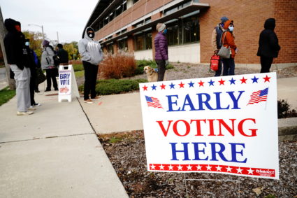 People queue to enter a polling site at the Milwaukee Public Library’s Washington Park location in Milwaukee, on the first day of early voting in Wisconsin, U.S., October 20, 2020. Photo by REUTERS/Bing Guan