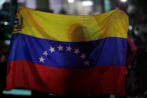 A woman holds a Venezuelan flag while participating in a candlelight vigil held for victims of recent violence in Caracas, Venezuela May 5, 2019. Photo by Ueslei Marcelino/REUTERS