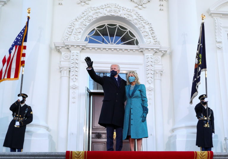 U.S. President Joe Biden waves next to first lady Jill Biden as they stand at the North Portico of the White House, in Washington, U.S., January 20, 2021. Photo by Tom Brenner/REUTERS