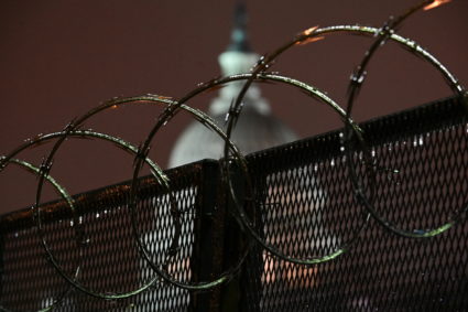 The U.S. Capitol is seen through barbed wire on a security fence after the Senate voted to acquit former U.S. President Donald Trump during his impeachment trial, in Washington, U.S. February 13, 2021. Photo by Erin Scott/REUTERS