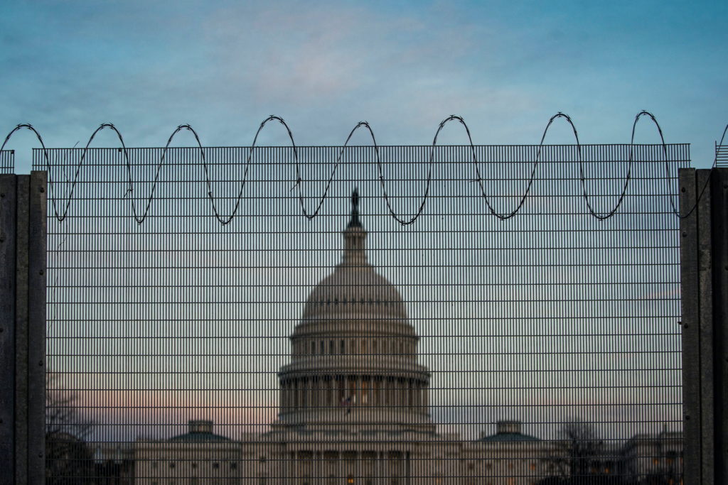 Barbed wire and protective fencing surrounds the U.S. Capitol, as the sun sets in Washington, U.S., February 21, 2021. Pho...