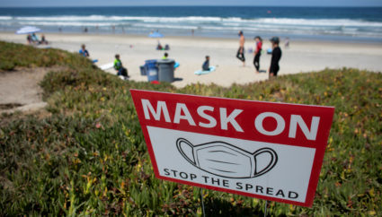 A sign requiring the use of masks is seen at the beach when California reported its largest number of new coronavirus infections in a single day, during the outbreak of the coronavirus disease (COVID-19) in Del Mar, California, U.S., July 15, 2020. Photo by Mike Blake/REUTERS