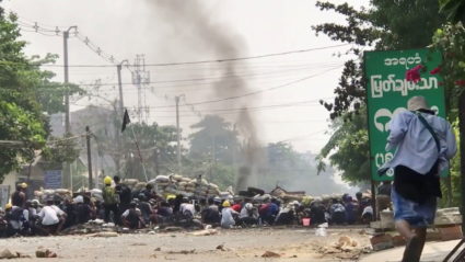 Demonstrators hide behind a barricade during protests against the military coup in Yangon, Myanmar on March 28, 2021 in this screen grab taken from a social media video obtained by Reuters.