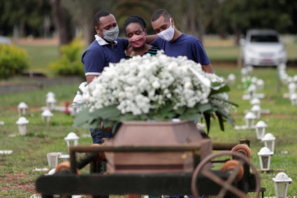 Gerson James, 34, and Jeferson James, 18, embrace their mother Izenilde Jesus, 55, during the funeral of their father Frank James Santana, 54, who died from the coronavirus disease (COVID-19), at the Campo da Esperanca cemetery, in Brasilia, Brazil, April 29, 2021. Photo by REUTERS/Ueslei Marcelino