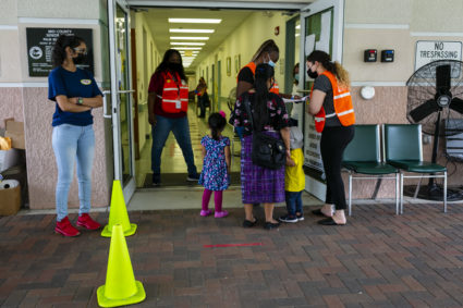 A woman confers with officials while waiting for her turn to get vaccinated at a COVID-19 vaccine event in southern Florida on April 24, 2021. Photo by Eva Marie Uzcátegui