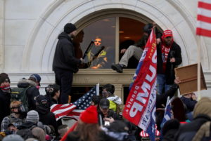 A mob of supporters of then-U.S. President Donald Trump climb through a window they broke as they storm the U.S. Capitol Building in Washington, U.S., January 6, 2021.