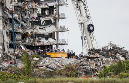 Emergency workers conduct search and rescue efforts at the site of a partially collapsed residential building in Surfside