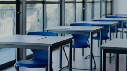 Inside a classroom with desks and chairs spaced out.