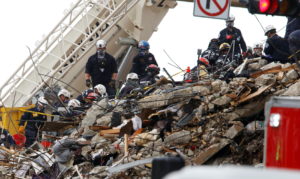 Emergency workers conduct search and rescue efforts at the site of a partially collapsed residential building in Surfside
