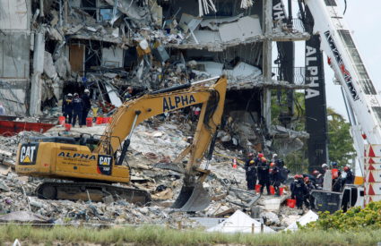 Emergency workers conduct search and rescue missions at the site of a partially collapsed residential building in Surfside