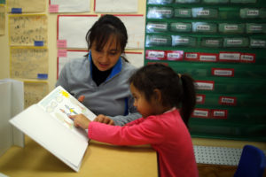 Garcia reads a book with her three-year-old daughter at ABCD Head Start program in the Roslindale neighborhood of Boston