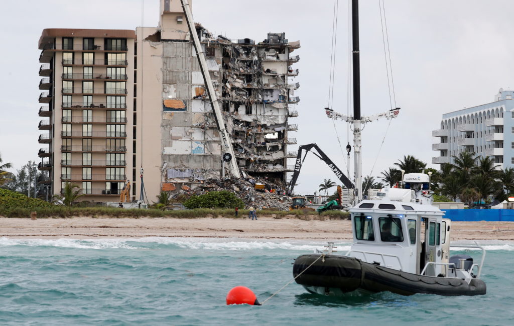 A Miami-Dade County police boat sits at anchor as emergency workers conduct search and rescue efforts at the site of a par...