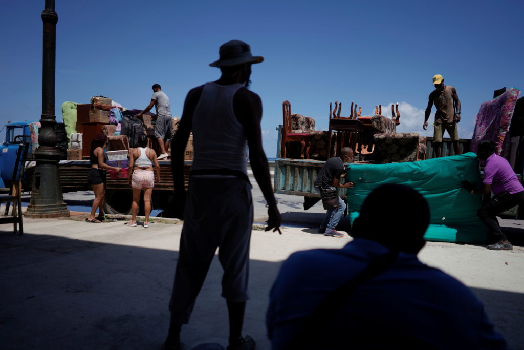 People load trucks with furniture to be relocated prior to the arrival of Storm Elsa, in Havana