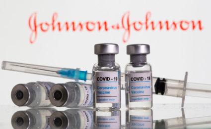 FILE PHOTO: Vials labelled "COVID-19 Coronavirus Vaccine" and sryinge are seen in front of displayed J&amp;J logo in this ...