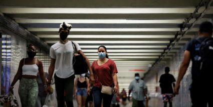 People wear masks as they pass through a pedestrian subway as cases of the infectious coronavirus Delta variant continue t...