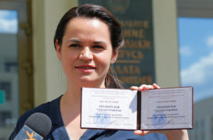 Presidential candidate Svetlana Tikhanovskaya shows her registration certificate as she leaves the central election commis...