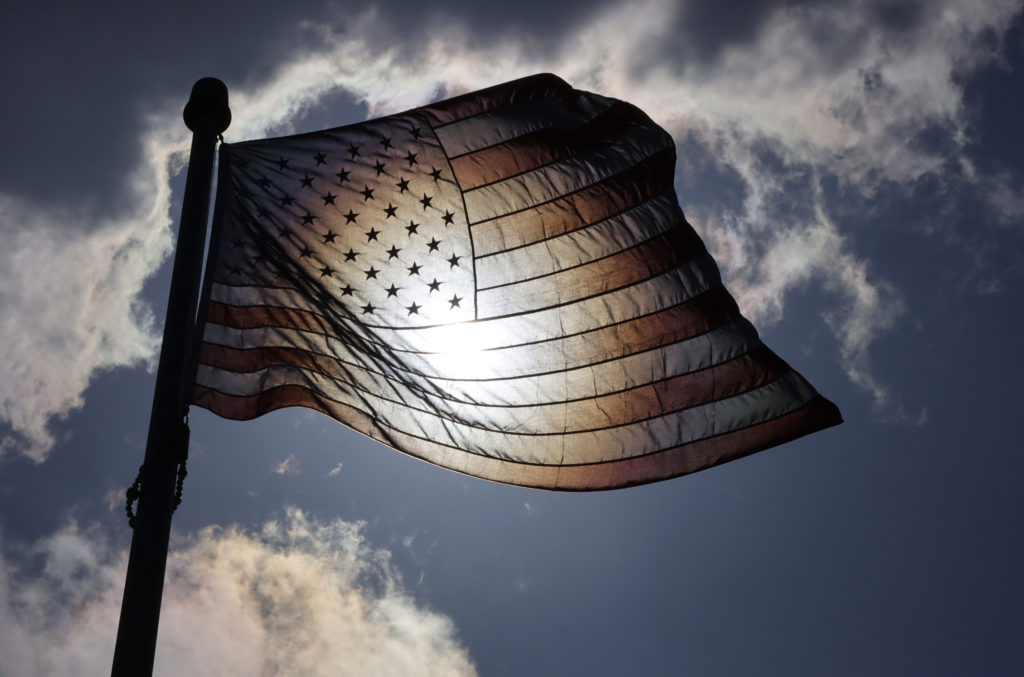 The sun shines through an American Flag at Mt. Mitchell Scenic Overlook in Atlantic Highlands, New Jersey