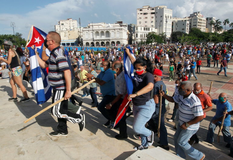 Government supporters walk during protests against and in support of the government, in Havana