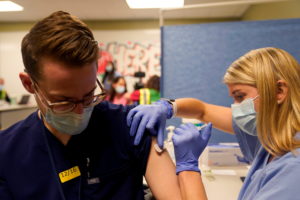 FILE PHOTO: The Pfizer-BioNTech coronavirus disease (COVID-19) vaccines are administered to healthcare professionals, in I...