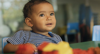Happy baby playing with toy blocks.