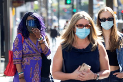 FILE PHOTO: People wearing face protective masks walk on Hollywood Blvd during the outbreak of the coronavirus disease (CO...