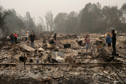 The Webber family searches for belongings through their home, which was gutted by the Almeda fire, in Talent, Oregon