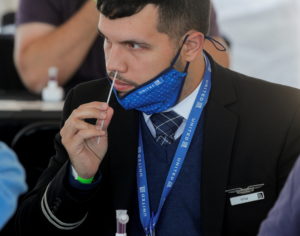 FILE PHOTO: A United Airlines employee swabs his nose for a coronavirus disease (COVID-19) test to attend a mass reunion e...