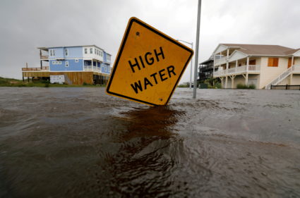 FILE PHOTO: Flood waters lap at a high water warning sign that was partially pushed over by Hurricane Florence on Oak Isla...