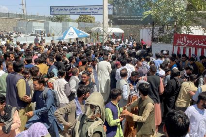 A crowd of people scrambles to try to get into Hamid Karzai International Airport in Kabul, Afghanistan, on August 16, 2021.